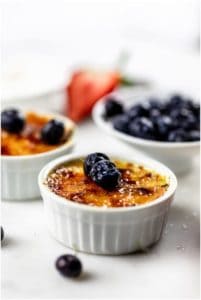 Creamy blueberry crème brûlée with fresh blueberries and a caramelized sugar crust on top. Perfect for dessert lovers seeking a delicious and elegant treat.